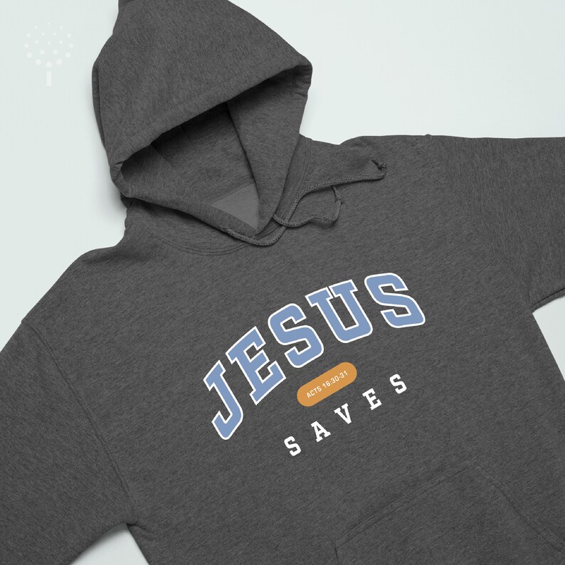 May include: A dark gray hooded sweatshirt with the text "JESUS SAVES" in blue and white lettering. The text "ACTS 18:30-31" is in a small orange rectangle.
