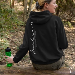 May include: Black hooded sweatshirt with white text on the back that reads "Joshua 1:9" and the quote "For I have commanded you to be strong and courageous. Do not be afraid; do not be discouraged, for the Lord your God will be with you wherever you go."