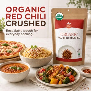 Op de afbeelding: Een bruine hersluitbare zak met het label Organic Red Chili Crushed en een USDA Organic-zegel. De zak staat naast een kom pasta, een kom soep, een bord geroosterde groenten en een pizza, allemaal bestrooid met rode chilivlokken.