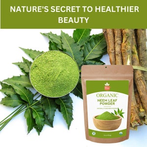 May include: A brown paper bag with a label that reads "Organic Neem Leaf Powder" and a picture of a bowl of green powder. The bag is sitting on a white surface with green leaves and brown sticks.