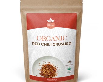 May include: A brown paper bag with a red label that says "Organic Red Chili Crushed". The label also includes a small logo with a cup and leaves, and the text "Spicy Organic". The bag contains 16 ounces (454 grams) of crushed red chili peppers.