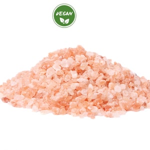 Pu&ograve; includere: Primo piano di un mucchio di cristalli di sale rosa dell'Himalaya. Il sale &egrave; di colore rosa chiaro e ha una consistenza ruvida.