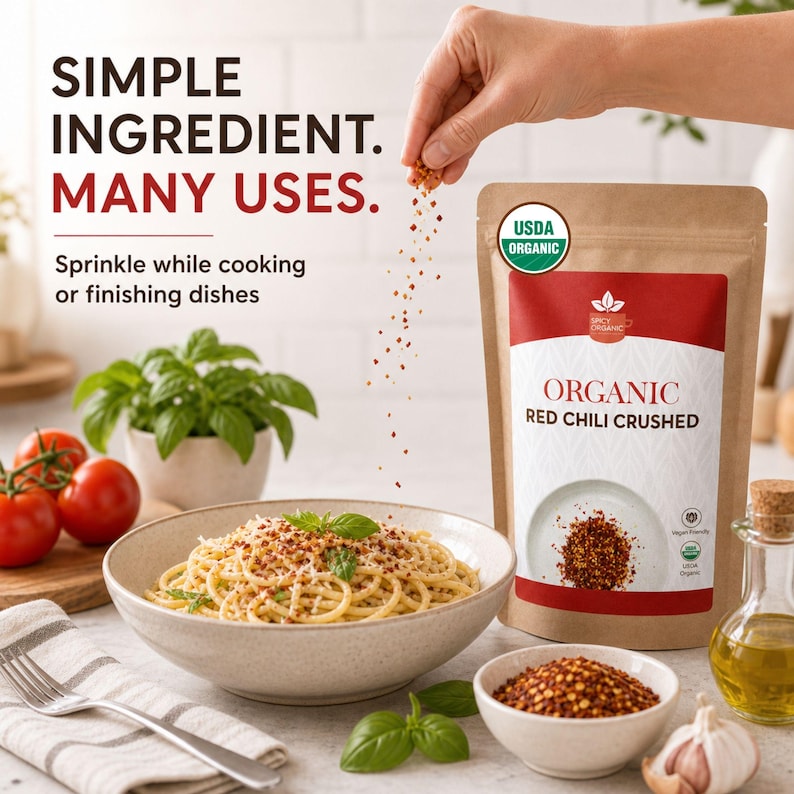 Op de afbeelding: Een bruine papieren zak met het label Organic Red Chili Crushed en een USDA Organic zegel. De tekst luidt Simple Ingredient. Many Uses. Sprinkle while cooking or finishing dishes. Rode chilivlokken worden over een kom spaghetti gestrooid.