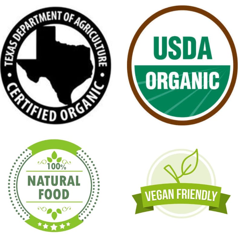 May include: Four green and brown circular labels with white text. The top left label is black with white text and a silhouette of the state of Texas. The text reads "Texas Department of Agriculture Certified Organic". The top right label is brown with a green circle inside. The text reads "USDA Organic". The bottom left label is green with white text and a small green leaf design. The text reads "100% Natural Food". The bottom right label is green with white text and a small green leaf design. The text reads "Vegan Friendly".