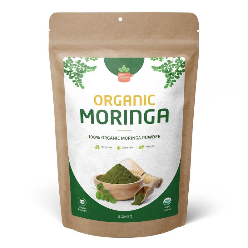 May include: A brown kraft paper pouch containing 16 oz of organic moringa powder. The label features the text Organic Moringa, 100% Organic Moringa Powder, and icons for vitamins, minerals, and protein, with a wooden bowl of green powder.