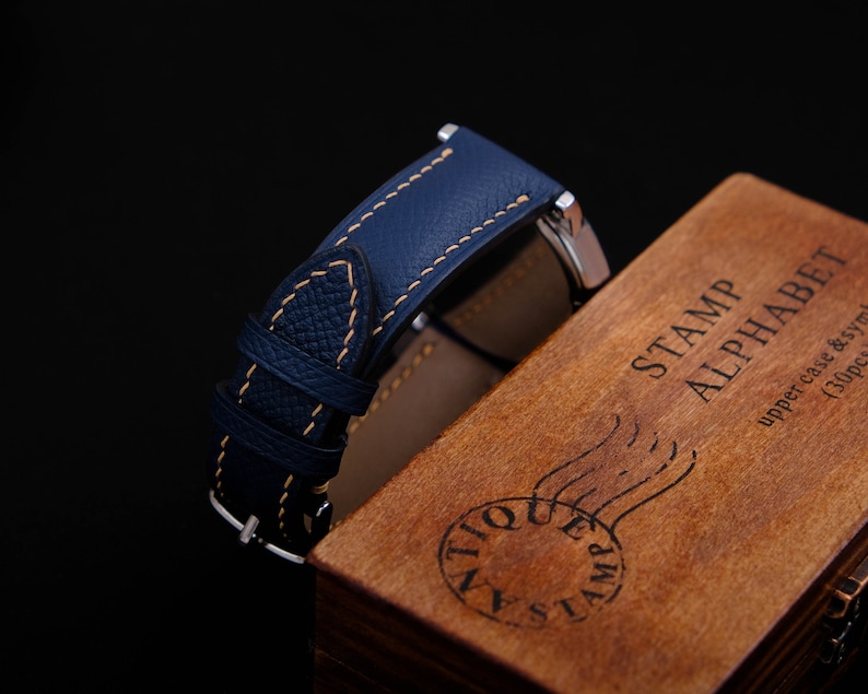 May include: A blue leather watch strap with yellow stitching, resting on a wooden box with the text "STAMP ALPHABET upper case & symbol (30pcs)".