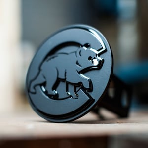 May include: Black metal hitch cover with a raised, stylized bear silhouette inside a circle.