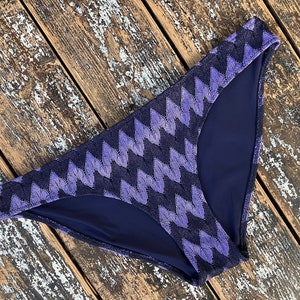 Puede incluir: Braga de bikini azul marino y morado con un patrón de chevron.