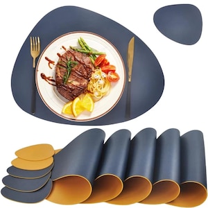 Pode incluir: Conjunto de seis tapetes de mesa azuis e amarelos. Os tapetes de mesa são feitos de um material semelhante ao couro e têm uma forma orgânica única. Os tapetes de mesa são mostrados com um prato, talheres e comida.