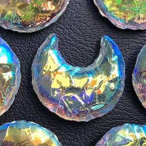 May include: Five iridescent glass moon shapes, with a crescent moon shape in the center. The glass is clear with a rainbow iridescent finish.