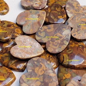 May include: A collection of heart-shaped polished stones with a brown, yellow, and green marbled pattern. The stones are arranged in a pile and have a glossy finish.  StoneSupplier is printed on several of the stones.