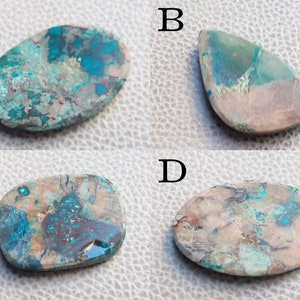 K&ouml;nnte beinhalten: Vier Cabochon-Edelsteine mit einer Mischung aus braunen, wei&szlig;en und t&uuml;rkisblauen Farben. Die Steine sind oval und tropfenf&ouml;rmig.