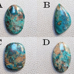 K&ouml;nnte beinhalten: Vier t&uuml;rkisfarbene, braune und wei&szlig;e Cabochon-Edelsteine, die mit A, B, C und D gekennzeichnet sind. Die Edelsteine sind oval und tropfenf&ouml;rmig.