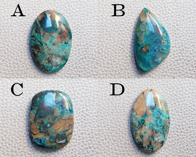 K&ouml;nnte beinhalten: Vier t&uuml;rkisfarbene, braune und wei&szlig;e Cabochon-Edelsteine, die mit A, B, C und D gekennzeichnet sind. Die Edelsteine sind oval und tropfenf&ouml;rmig.