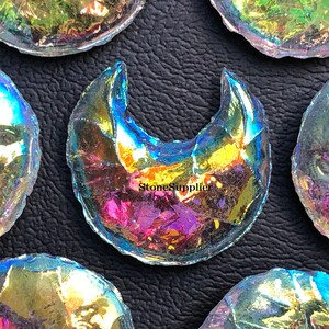 May include: A collection of iridescent glass moon and full moon shapes. The glass is clear with a rainbow sheen.