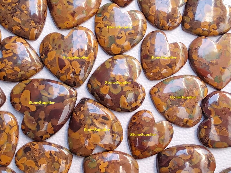 May include: A collection of 14 heart-shaped polished stones with a brown, orange, and green marbled pattern. The stones are approximately 5 cm in length and 4 cm in width.