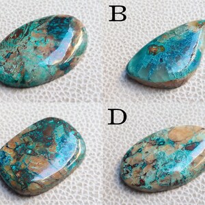 K&ouml;nnte beinhalten: Vier ovale T&uuml;rkis-Cabochons mit braunen und kupferfarbenen Einschl&uuml;ssen. Die Cabochons sind mit A, B, C und D gekennzeichnet.