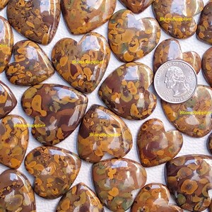 May include: A collection of 20 heart-shaped polished stones with a brown, orange, and green marbled pattern. The stones are approximately the size of a UK 20 pence coin.