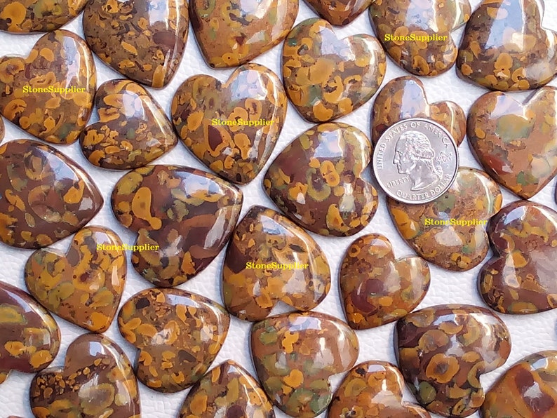 May include: A collection of 20 heart-shaped polished stones with a brown, orange, and green marbled pattern. The stones are approximately the size of a UK 20 pence coin.