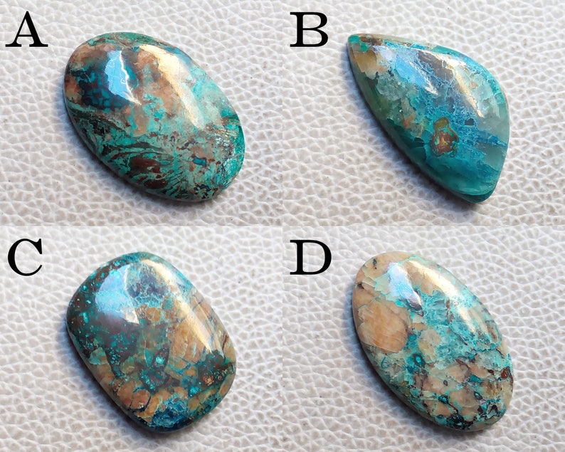 K&ouml;nnte beinhalten: Vier ovale T&uuml;rkis-Cabochons mit Kupfer- und Brauneinschl&uuml;ssen. Die Cabochons sind mit A, B, C und D gekennzeichnet.