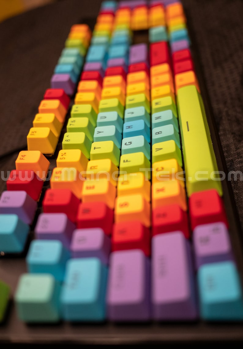 May include: A close-up shot of a rainbow-colored mechanical keyboard. The keycaps are arranged in a standard layout, with each row displaying a different color, creating a vibrant and eye-catching design. The keys are labeled with white letters.