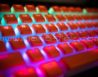 May include: A close-up of a bright orange mechanical keyboard with rainbow LED backlighting. The keys are illuminated with a vibrant glow, creating a colorful and dynamic effect.