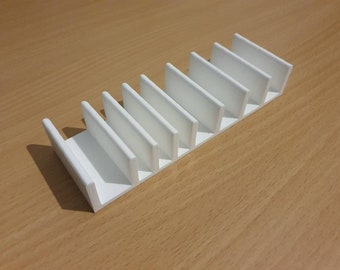 Op de afbeelding: Witte plastic organizer met zeven vakken om spullen in op te bergen. De organizer is gemaakt van glad, wit plastic en heeft een rechthoekige vorm.