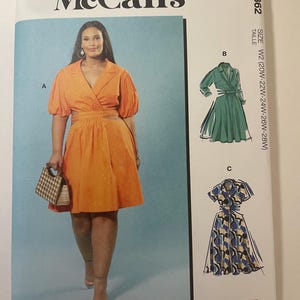 May include: McCall's sewing pattern featuring a woman in an orange dress. The pattern includes multiple view options with simple instructions. The size is W2 (20W-22W-24W-26W-28W). Designed and printed in the USA.