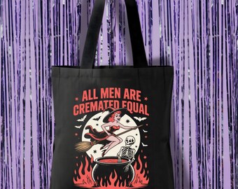 May include: Black tote bag with a Halloween-themed graphic. The design features a witch on a broom, a skeleton, and a cauldron with flames. The text "ALL MEN ARE CREMATED EQUAL" is printed above the graphic.