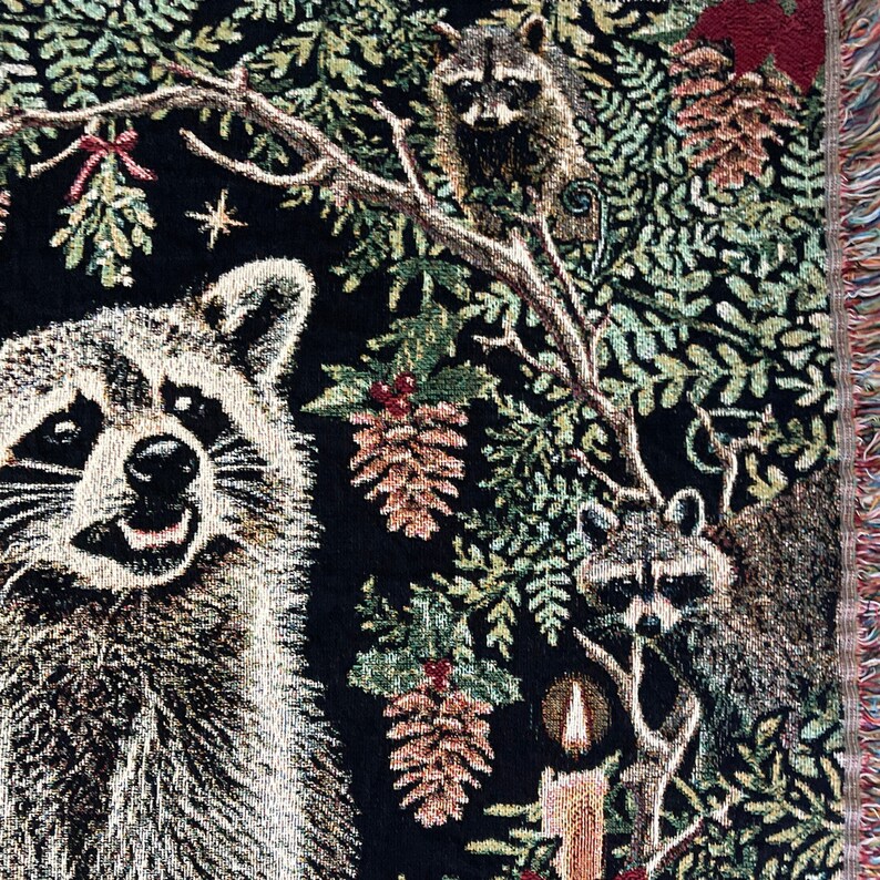 Raccoon woven tapestry blanket with candles, pinecones, winter greenery, mistletoe and holly berries.