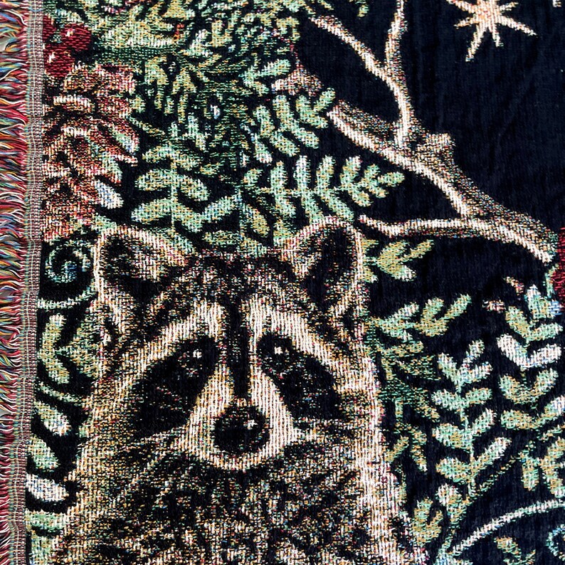 Raccoon Christmas Holiday blanket. The perfect raccoon Christmas gift for raccoon lovers, this raccoon woven tapestry blanket has six detailed raccoons woven into a black background. The raccoons are surrounded by winter botanicals and red bows.