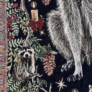 Close up of baby raccoon on this christmas raccoon woven blanket with fringe.