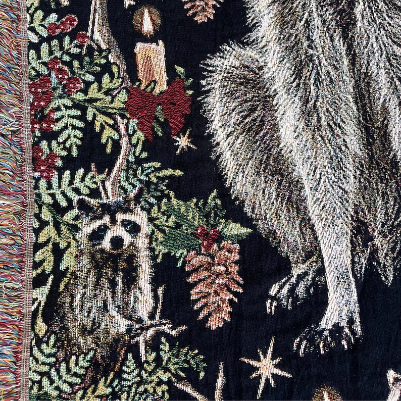 Close up of baby raccoon on this christmas raccoon woven blanket with fringe.