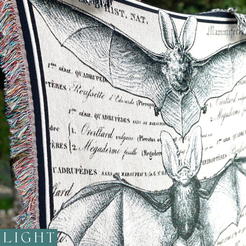 May include: A black and white tapestry featuring a detailed illustration of a bat with the text "HIST. NAT." and scientific classifications in French.