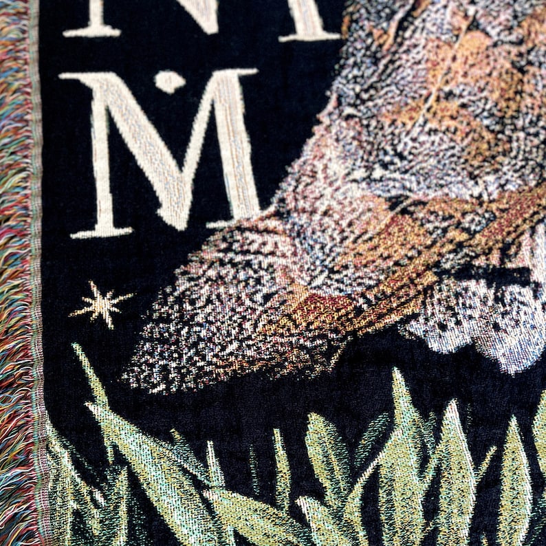 With a medieval tapestry aesthetic, this Barn Owl woven blanket with fringe has a dark academia decor aesthetic. The latin phrase Natura In Minima Maxima in vintage font surrounding the large Barn owl is perfect for the nature lover in your life.