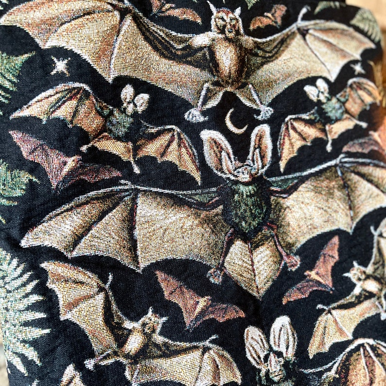 This vintage aesthetic bat tote bag has vintage aesthetic bats woven on the front and back with green ferns travelling up both sides of the tote bag.