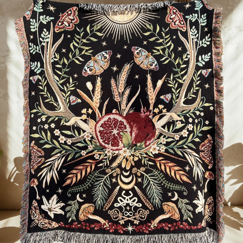 The story of Persephone and Hades woven into a cotton woven blanket with fringe. Hades symbolism is woven on the bottom of the blanket with Persephone's spring time return woven on the top. A central pomegranate separates the two worlds.
