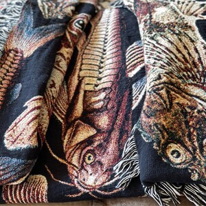The ulitmate gift for a fisherman, this vintage fish tapestry blanket has a black background and is covered in woven fish. Close up detail of antique fish woven throw blanket