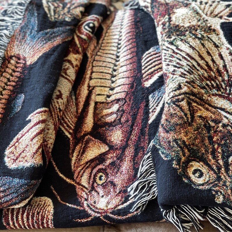 The ulitmate gift for a fisherman, this vintage fish tapestry blanket has a black background and is covered in woven fish. Close up detail of antique fish woven throw blanket