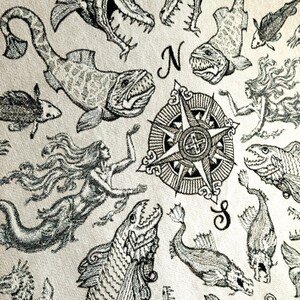 Vintage sea creature / mystical sea creature woven blanket. Deep sea mystical sea creatures with mermaids & and central compass in a vintage pirate map scene.