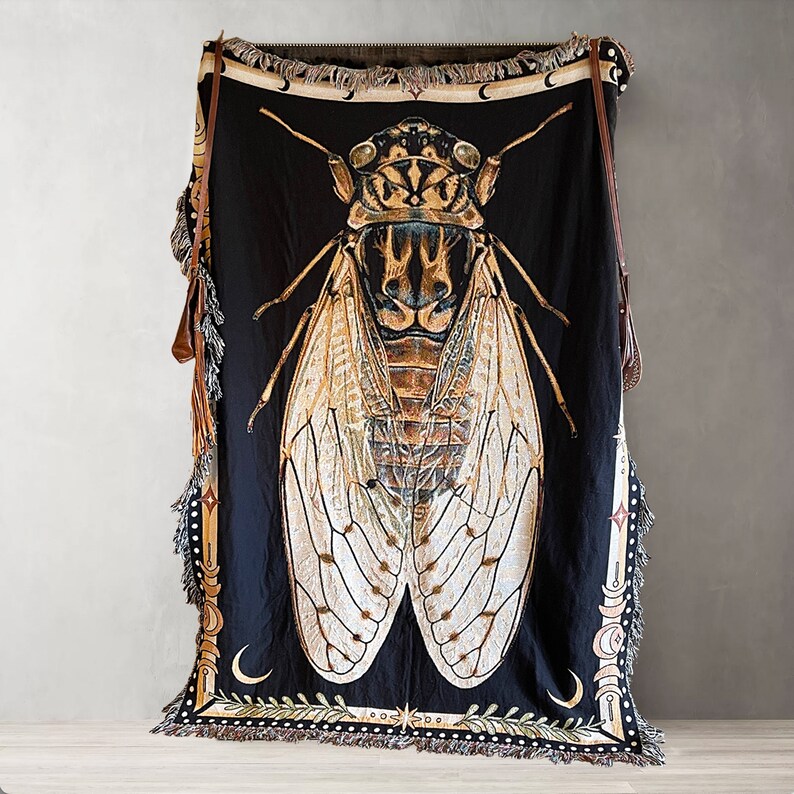 Whimsigoth woven blanket with fringe. This Cicada cotton black woven blanket with large cicada woven into it. A white and gold border with moon phases and crescent moons gives this blanket a mystical, boho vibe. The large cicada is very detailed.