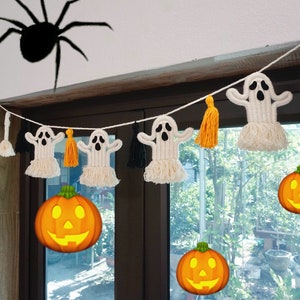 May include: A Halloween-themed garland featuring white ghost figures, orange tassels, and smiling jack-o'-lanterns. A large black spider is above the garland. The garland is strung across a window frame, creating a festive and spooky atmosphere.