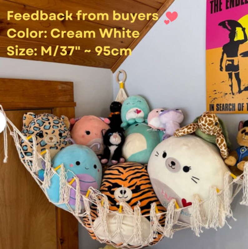 May include: A white macrame hammock with a variety of plush toys inside. The hammock is hanging from the ceiling and is filled with stuffed animals, including a tiger, a seal, a turtle, and a few others. The hammock is 37 inches wide and 95 centimeters long.
