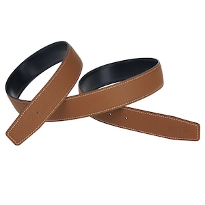 May include: A brown leather belt with a black lining and white stitching. The belt is folded in half and the stitching is visible on both sides.