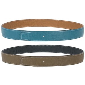 Può includere: Due cinture in pelle reversibili, una con una combinazione di colori blu turchese e marrone e l'altra con una combinazione di colori grigio scuro e marrone.