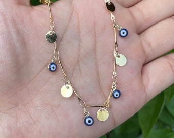 May include: Gold chain anklet with multiple small gold discs and blue evil eye charms.