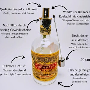 May include: A Don Papa rum bottle repurposed as a lamp with an 8mm permanent wick, a stainless steel windproof burner with child lock, a brass threaded refill plate, and a stainless steel wick extinguisher. The bottle is 25 cm tall with water-resistant labels.