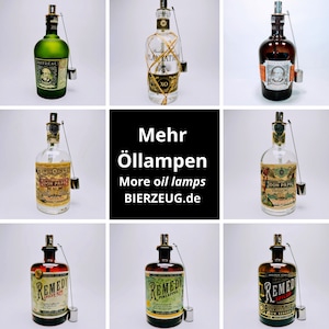 May include: Nine glass bottles with different labels and designs, repurposed as oil lamps. The bottles are filled with clear liquid and have a metal wick and chain attached to the top. The bottles are arranged in a 3x3 grid on a white background. The text "Mehr &Ouml;llampen" and "More oil lamps" is displayed in the center of the image.