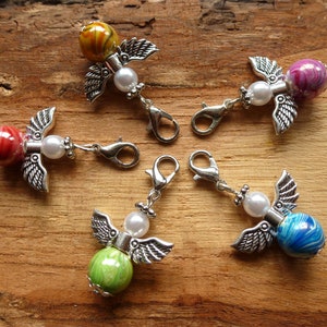 Puede incluir: Cinco abalorios de ángel de plata con cuentas de vidrio de colores. Cada abalorio tiene una cuenta de perla blanca y un cierre de langosta de plata.