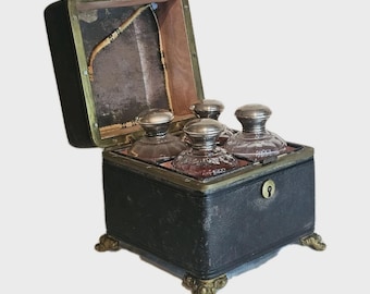 Une mallette d'apothicaire 19THC contenant quatre bouteilles en verre avec couvercles en argent sterling